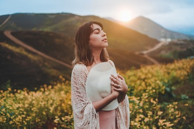 站在黄花地上戴着白帽子的女人